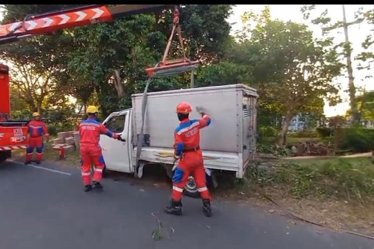 Tabrak Pohon, Mobil Box Muatan Oli Terbalik di Jalan Wiyung